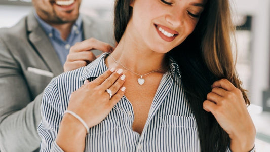 What is Moissanite - Guide & Definition - Happy woman trying jewelry in shop with seller